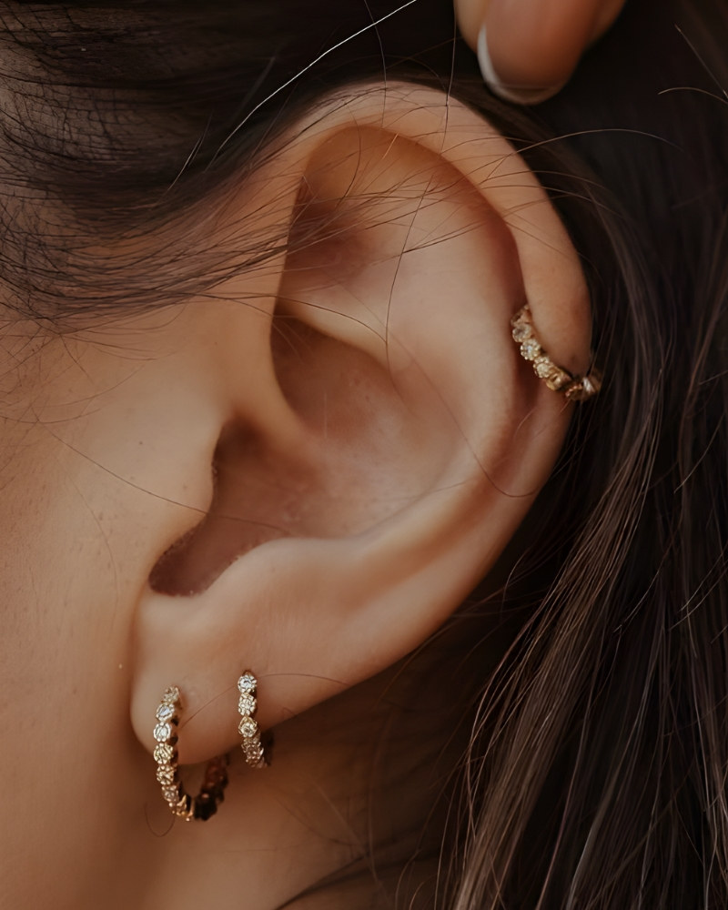 Gros plan d’une oreille percée : hélix et double lobe